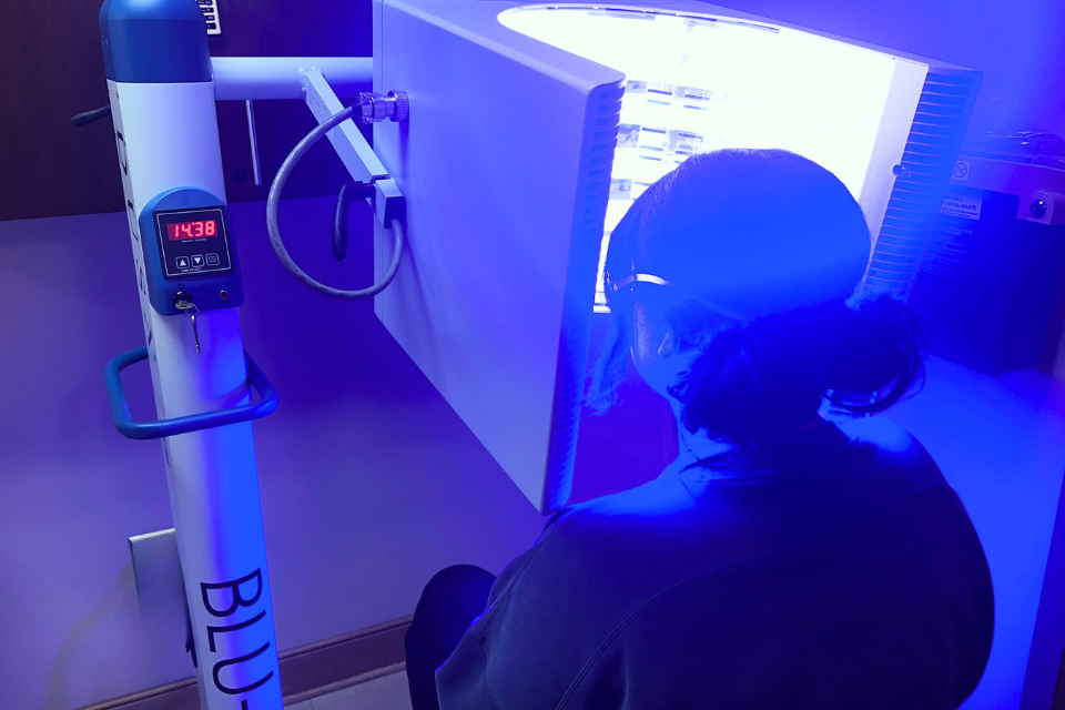 A patient receiving blue light therapy treatment.