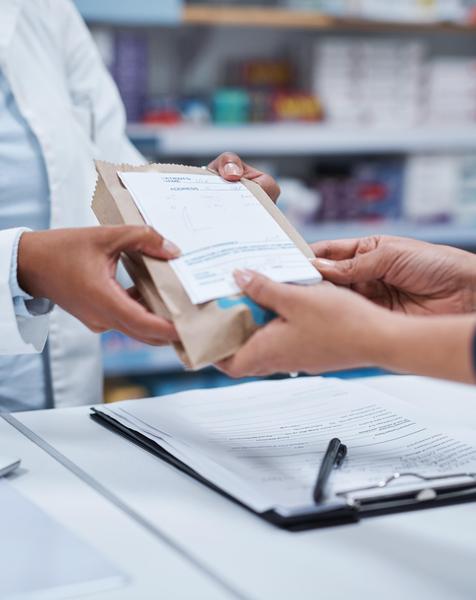 A pharmacist handing a patient medication.