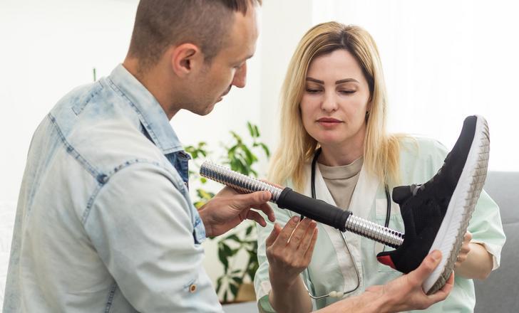 Two people learning about a prosthetic.