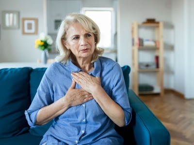 A person clutching her chest with heart attack symptom.