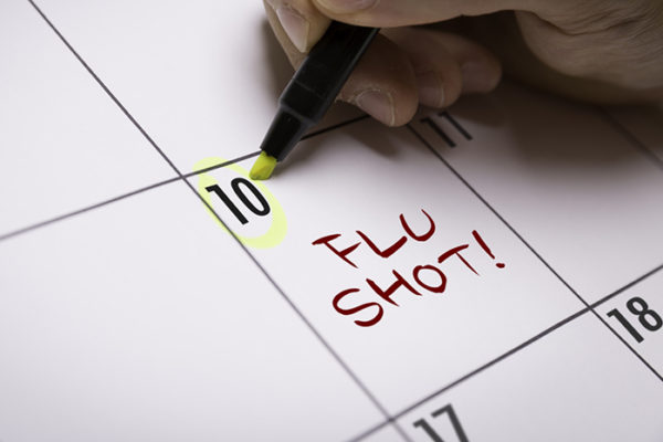 Marking a flu shot appointment on a calendar.