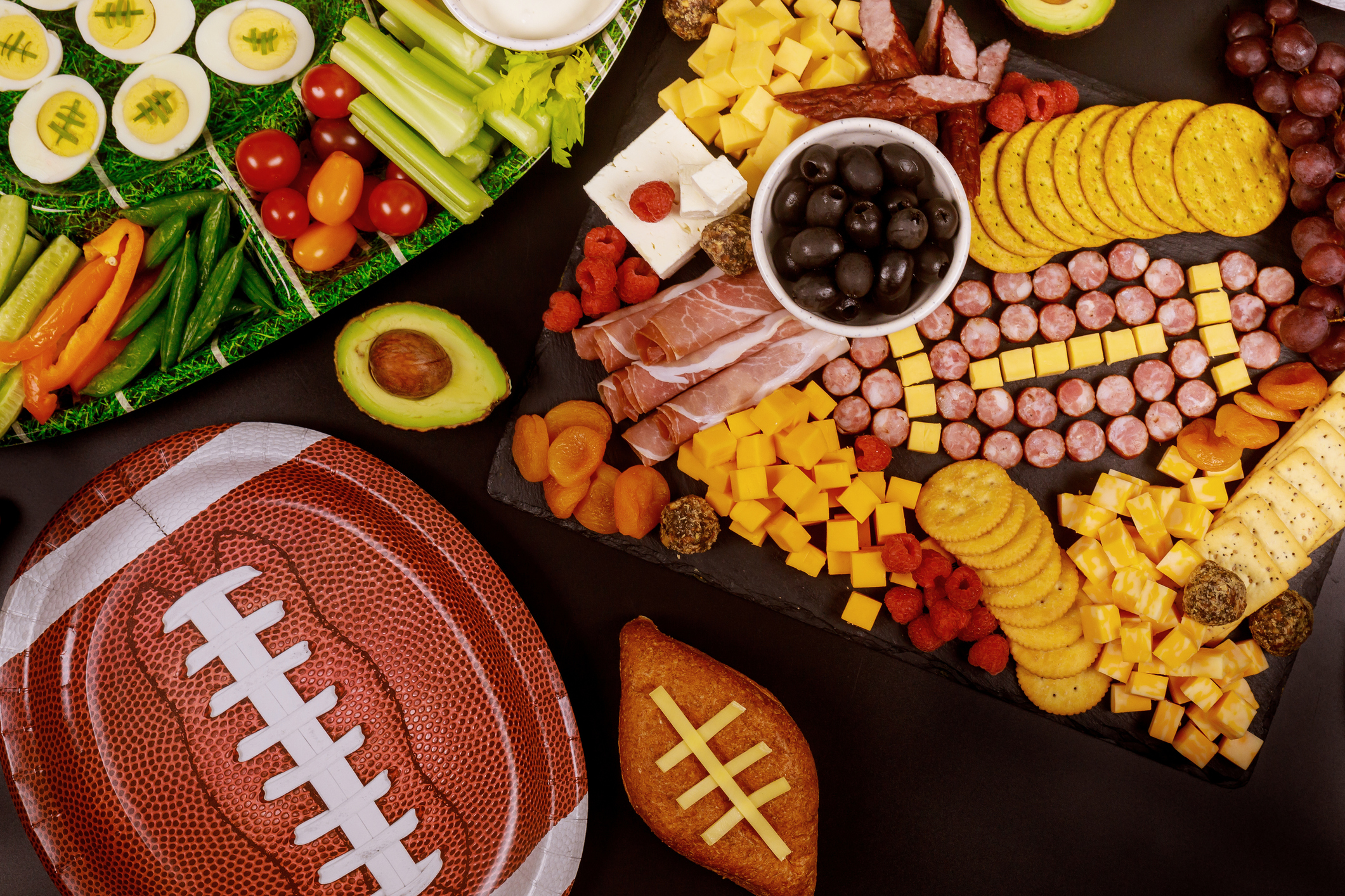 Healthy snacks, veggies, meat and cheeses with football plates
