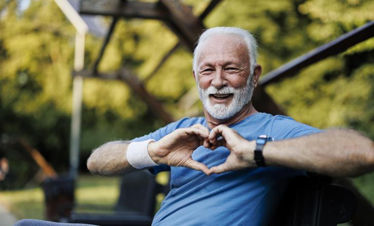 man holding hands up in heart shape