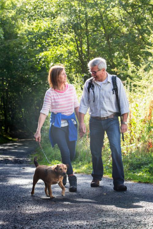 Older couple walking with dog