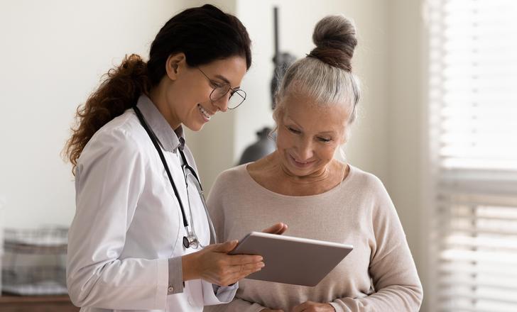 A doctor updating a patient on her results on an ipad.