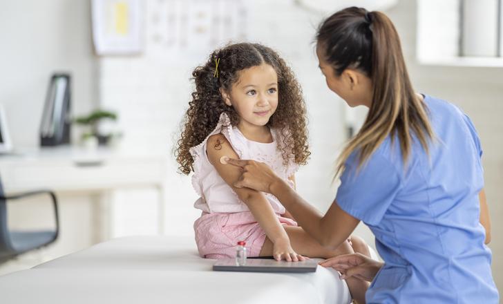 A doctor putting a bandaid on a young patient.