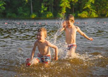 Two children swimming in a lake.