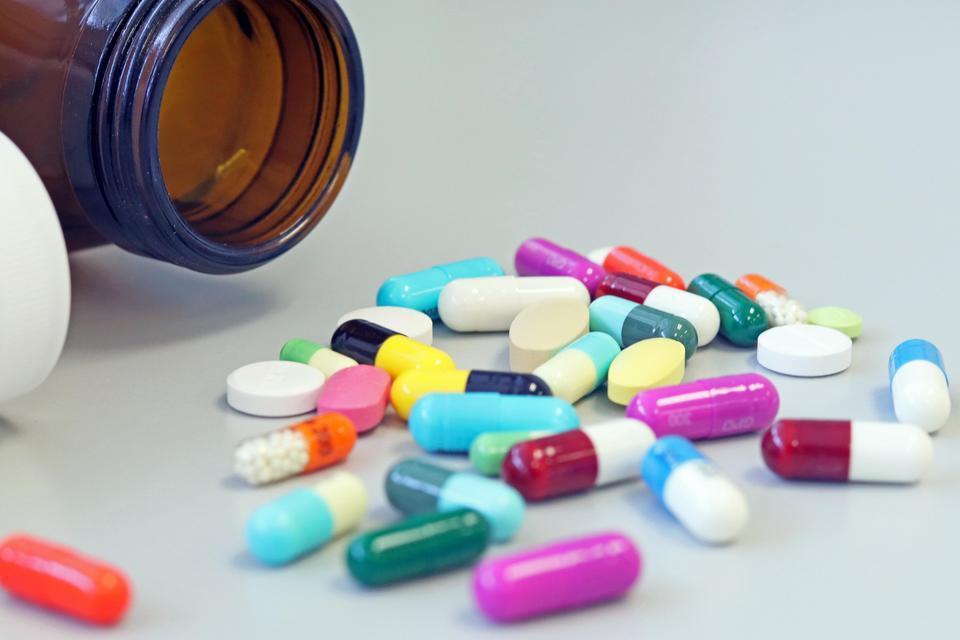 Pills from a medication bottle spilled on table.