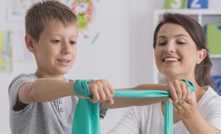 A pediatric therapist helping a patient.