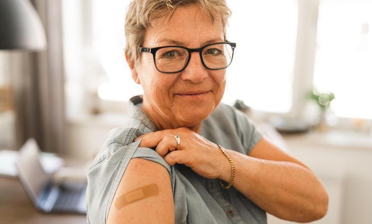 A person showing off their band aid after a vaccine.