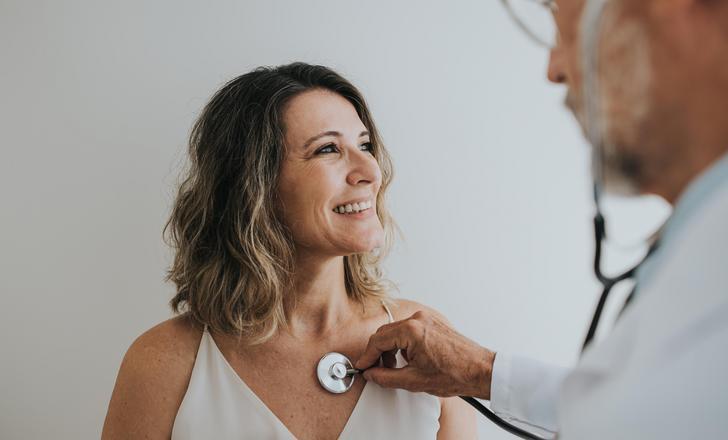 female patient with doctor listening to heart