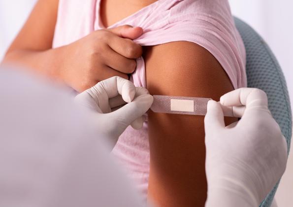 A child getting a bandaid after a shot.