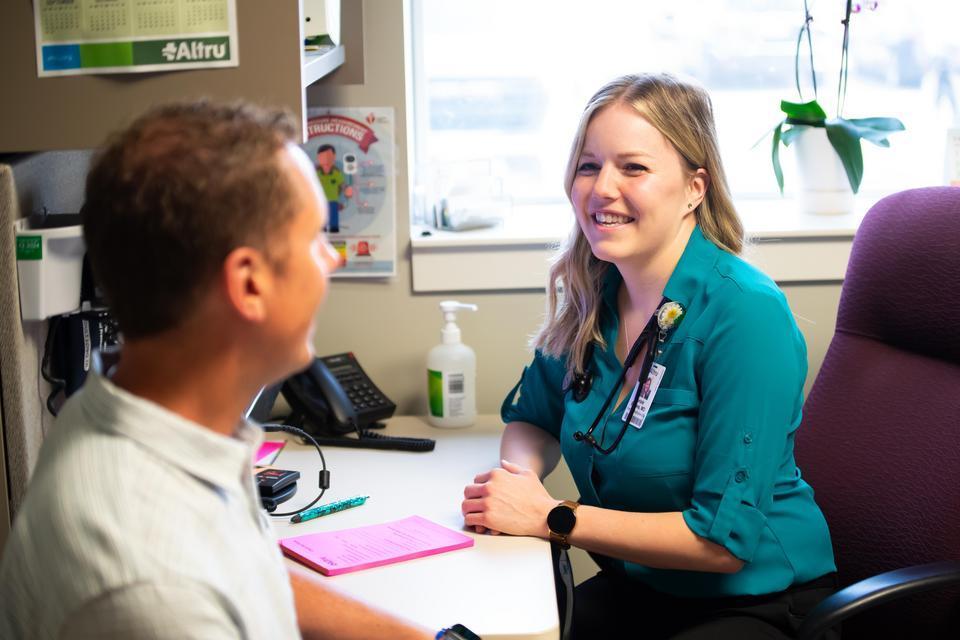 Kelsie Brooks talking to a patient at Altru.