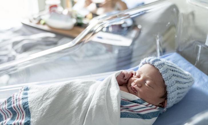 Newborn baby in a bassinet.