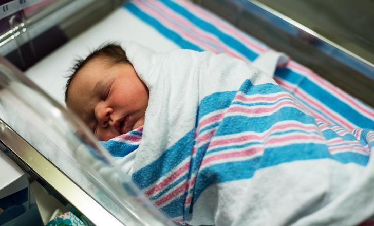 Newborn baby in a bassinet.