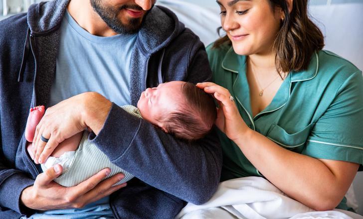 Parents holding their newborn after delivery.