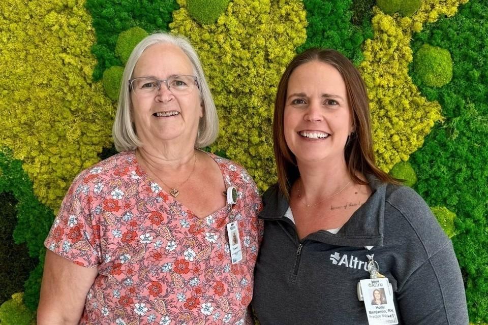 Portrait of Dawn Jenkins and Holly Benjamin in front of green wall
