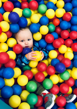 A toddler in a ball pit at a pediatric therapy appointment. 