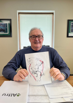 Jim Karley holding a drawing of a heart.