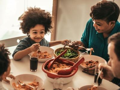 A family of four eating dinner at the dinner table.